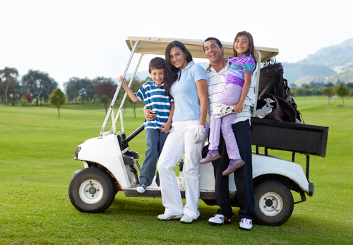 beautiful family portrait with a golf cart at the course