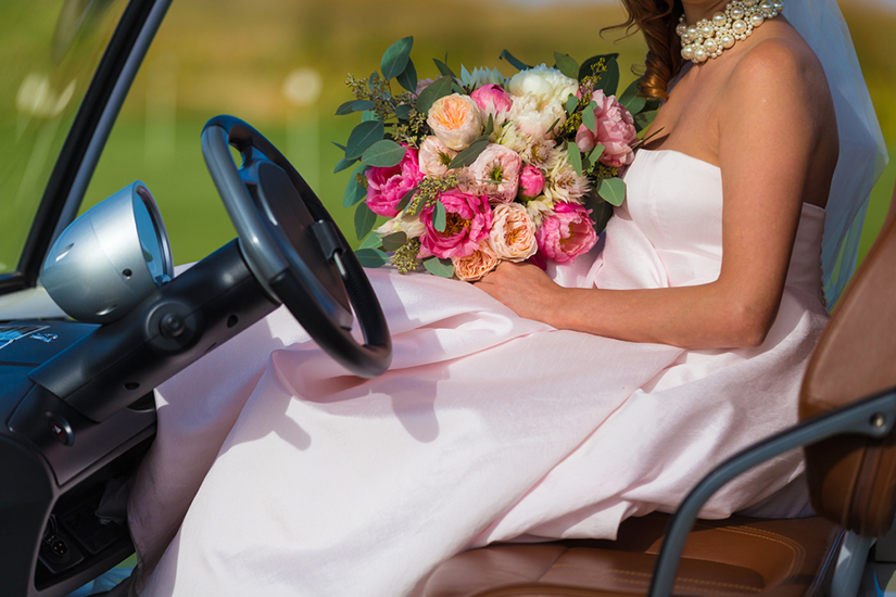 Bride with flowers in golf cart