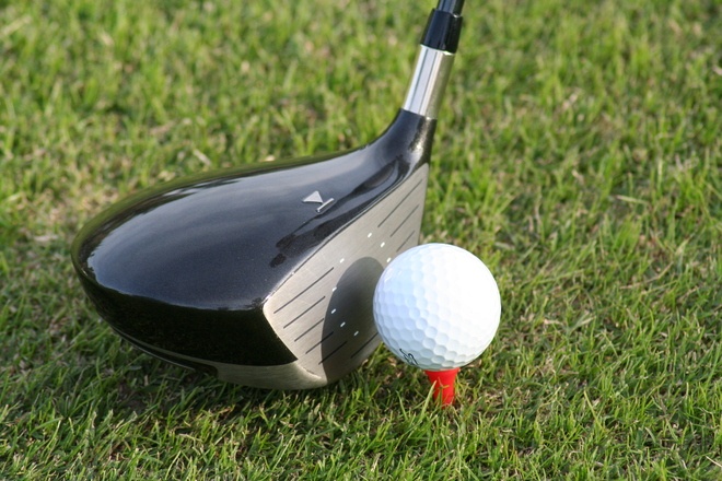 Golf club hitting golf ball