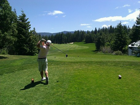 Golfer mid-swing in golf course