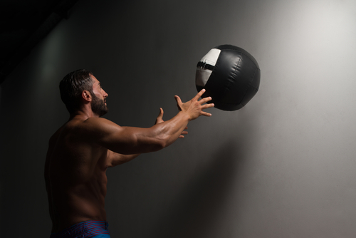 latin male athlete crouched doing wall exercise