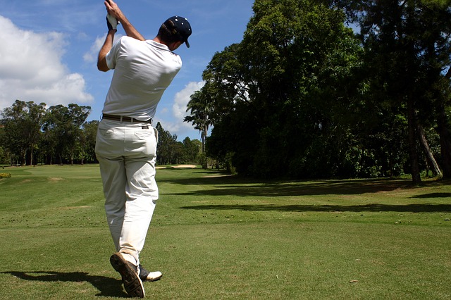 Man playing golf mid-swing
