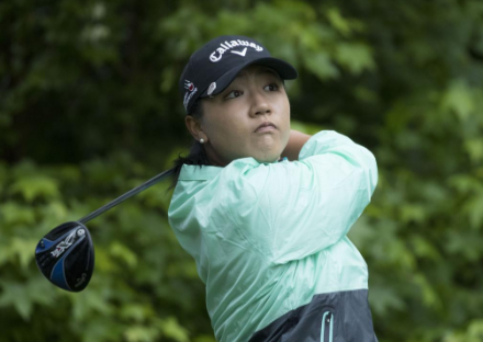 Womans face concentrating during golf swing